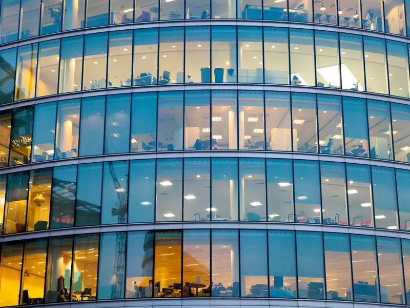 The glass windowed facade of a large office building.